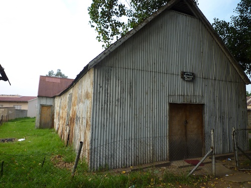 Figure 1. « Quand je revois ma p’tite église… ». L’église méthodiste de Comet, seule des trois églises encore en place et utilisée. Construite en tôle ondulée et située près de l’entrée de la cité (Gervais-Lambony, 2011).